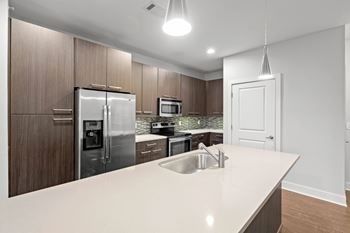 A modern kitchen with a white countertop and stainless steel appliances. at 46 Penn Apartment Homes, Missouri, 64111